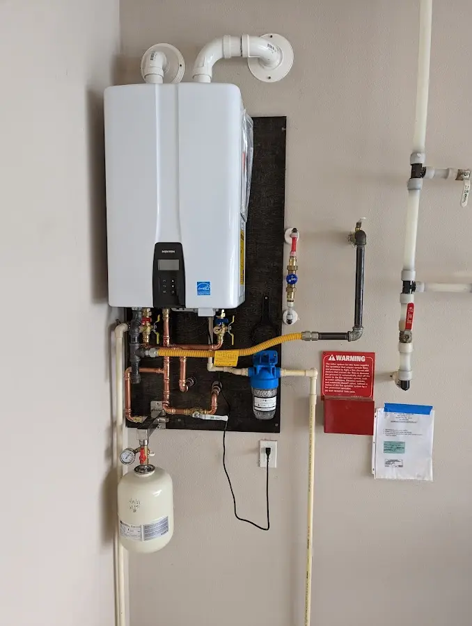 Professional plumber installing copper piping in a Portville home